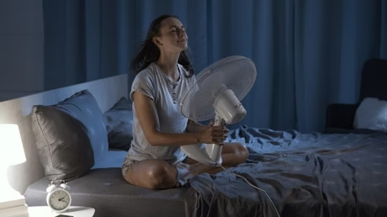 femme avec ventilateur pour mieux dormir pendant la chaleur